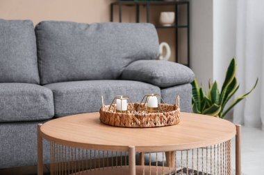 Evdeki masasında güzel mumlar olan hasır tepsi, yakın çekim.