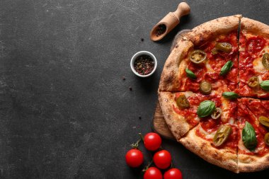 Lezzetli pizzalı kompozisyon ve koyu arkaplanda malzemeler