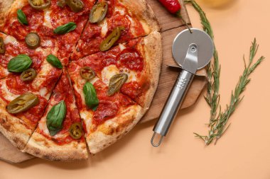 Bej arka planda lezzetli pizza ve kesiciler.