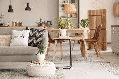 Modern mutfağın içinde kanepe, yemek masası ve bitkiler var.