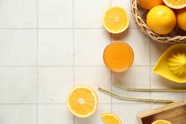 Bir bardak taze portakal suyu ve beyaz fayanslı meyve sepeti.