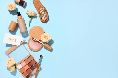 Renkli arka planda farklı dekoratif kozmetik ürünleri, satış etiketi ve çiçeklere sahip kompozisyon