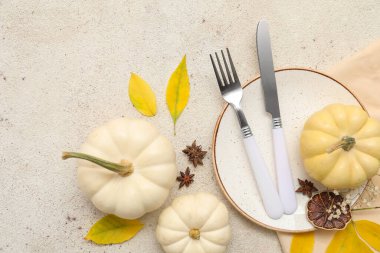 Sonbahar yaprakları, yıldız anasonu ve beyaz arka planda taze balkabaklarıyla güzel bir masa.