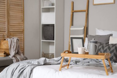 Yatak odasında çaydanlık, fincan ve çerçeve ile tepsi