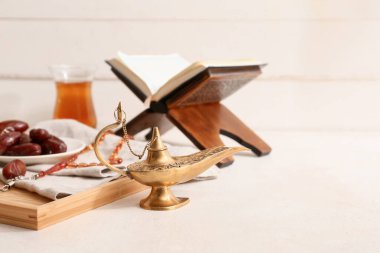 Aladdin lambası, tarihler ve Kur 'an beyaz masada tahta arka planda. Ramazan kutlaması