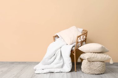 Oda da bej duvarın yanında temiz yatak çarşafları, puf ve yastıklar.