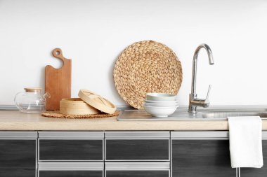 Mutfaktaki masada lavabo, kase ve hasır var.