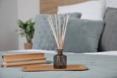 Aroma kamış ayırıcı tepside ve kitap yatak odasında. Yakın çekim.