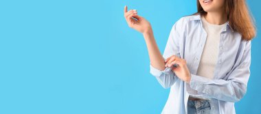 Genç bir kadın açık mavi arka planda kolunu kıvırıyor ve mesaj için yer açıyor.