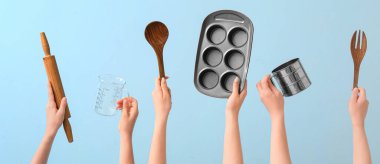 Mavi arkaplanda pişirme aletleri olan eller