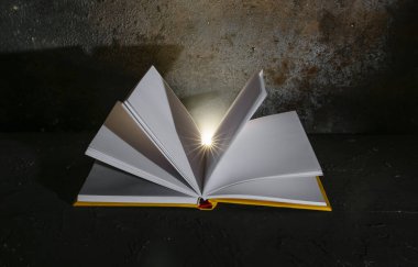 Koyu arkaplanda parlayan ışık ile kitabı aç