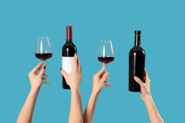 Mavi arka planda şişe ve şarap kadehleri olan kadınlar. Sevgililer Günü kutlaması