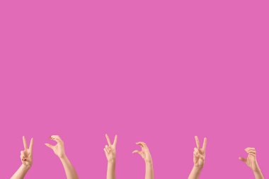 Mor arka planda barış ve kalp jestleri gösteren kadın elleri