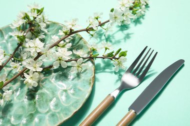 Turkuaz arka planda çiçek açan dalları olan güzel masa ayarları