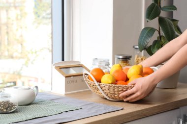 Kadın elleri, hafif mutfakta tezgahın üzerine nargileci sepeti koyuyor.
