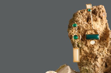 Gri arka planda güzel küpeleri olan taş.