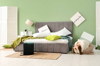 Yatak odasında deprem sırasında yatağın yanında saklanan kadın.