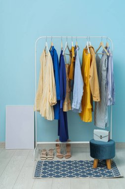 Mavi arka planda askıda asılı kadın giysileri