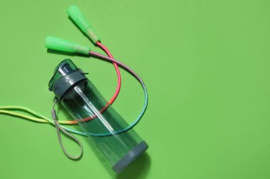 Spor su şişesi ve yeşil arka planda atlama ipi.