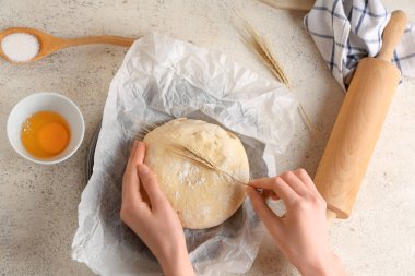 Taze hamur ve beyaz arka planda buğdaylı kadın elleri