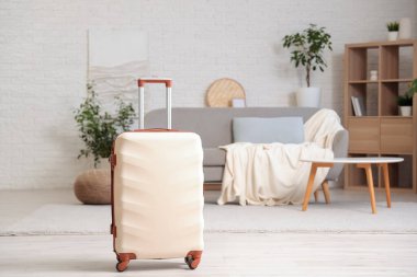 Oturma odasının iç tarafına beyaz bavul konmuş.