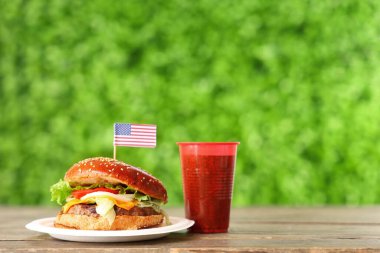 Lezzetli hamburger, bayrak ve kola açık havada, yakın plan. Amerikan Bağımsızlık Günü kutlamaları