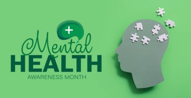 Yeşil arka planda yapboz parçaları olan kağıt insan kafası. Akıl Sağlığı Farkındalığı Ayı Afişi