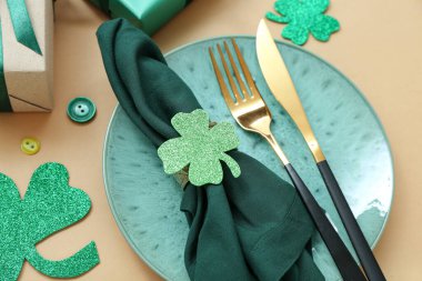 Beautiful table setting for St. Patrick's Day celebration on beige background