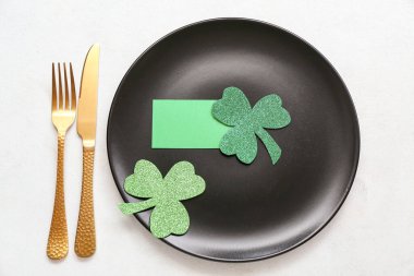 Beautiful table setting for St. Patrick's Day celebration on light background