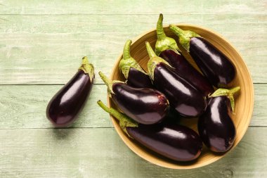 Yeşil ahşap arka planda taze patlıcan kasesi.