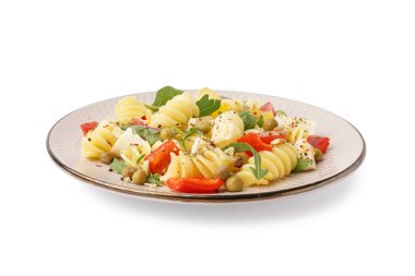 Beyaz arka planda biberli ve bezelyeli makarna salatası.