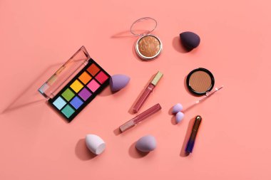 Pembe arka planda farklı dekoratif kozmetik ürünler