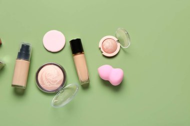 Yeşil arka planda farklı dekoratif kozmetik ürünler