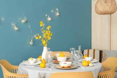 Şenlik odasında balkabakları ve sarı çiçeklerle sonbahar masası.