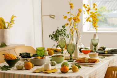 Çiçekler, yapraklar ve balkabaklarıyla sonbahar masası