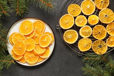 Siyah zemin üzerinde kurumuş portakal dilimleriyle kaplayın ve durun.