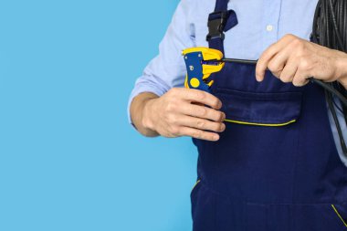 Mavi arka planda kriptolu ve telli erkek elektrikçi, yakın plan.