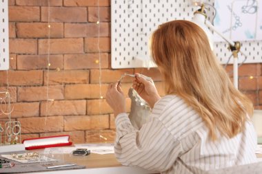 Atölyede çalışan kadın kuyumcu inceleme yüzüğü.