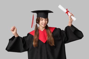 Gri arka planda diploması olan bekar elbiseli kız öğrenci.