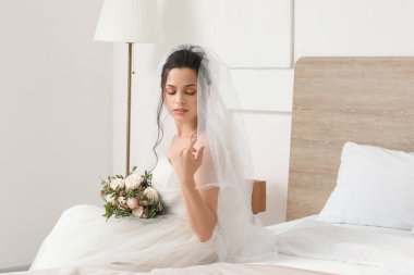 Gelin ve düğün buketi yatak odasında oturuyor.