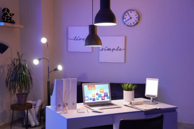 Laptop ve kısaltma SEO karanlık ofiste masanın üstünde.