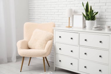 Şık çekmeceler ve oturma odasında yastıklı koltuklar.