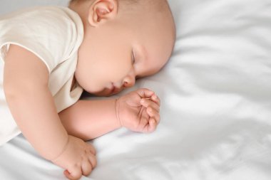 Yatakta uyuyan şirin küçük bebek, üst manzara.