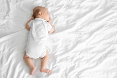 Yatakta uyuyan şirin küçük bebek, üst manzara.