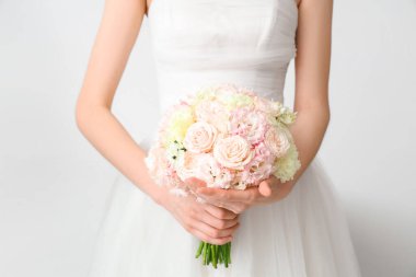 Açık arkaplanda düğün buketi olan güzel gelin