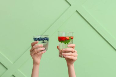 Yeşil zemin üzerinde erimiş su olan eller