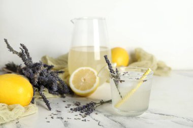 Beyaz arka planda çiçek ve limonlu taze lavantalı limonata.