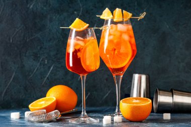 Mavi arka planda meyve ve şekerli Aperol sprey kokteyli.