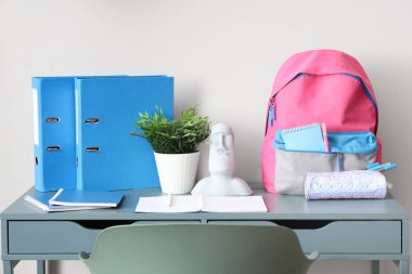 Beyaz duvarın yanındaki okul çantalı şık çocuk işyeri.