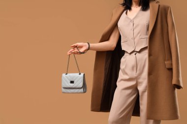 Bej arka planda şık mavi çantalı güzel genç bayan, yakın plan.